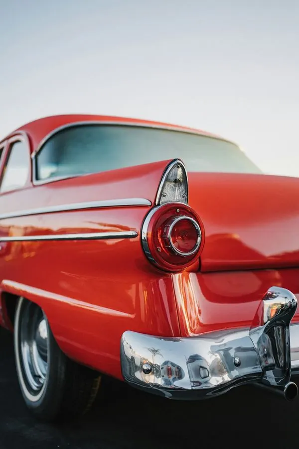 The tail fin of a red classic car